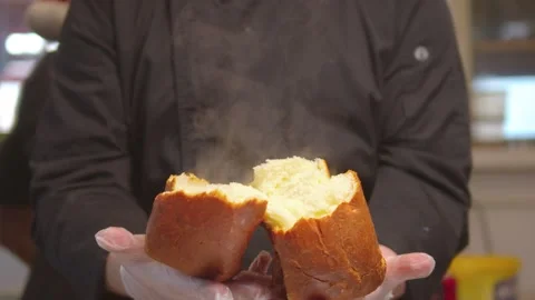 Baker breaking fresh steaming hot bread Stock Footage 326296946