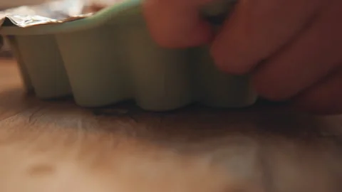 Baker carefully handling tray in warm home environment. Closeup of baker gently Stock Footage 342336013