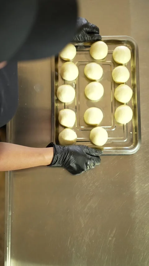 Baker Carrying a Tray of Cheese Bread or Bunuelos Ready for Baking Stock Footage 285862060