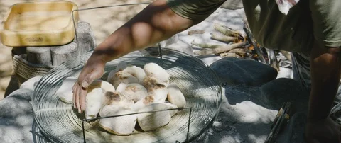 Baker checking buns on open fire stove Stock Footage 106211691