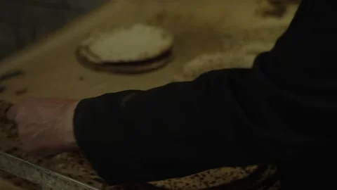 Baker checking traditional handmade round Matzah for Passover in a bakery Stock Footage 334995640