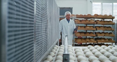 Baker chef and his two assistance showing the process of baking bread to the old Stock Footage 115639399