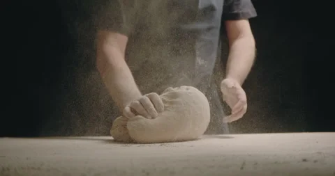 Baker clap hands with flour and kneading dough black background Stock Footage 254962355