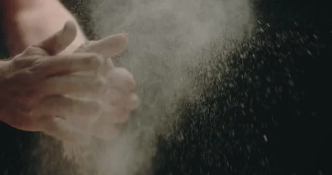 Baker clapping hands with flour black background Stock Footage 254960685