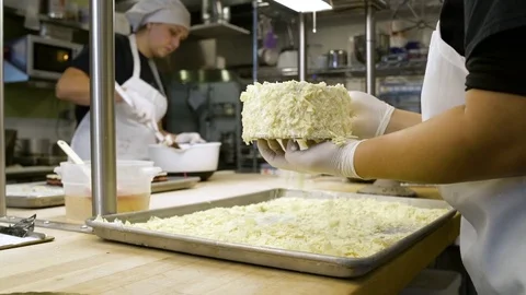 Baker covering a cake with almonds 動画素材 77080024