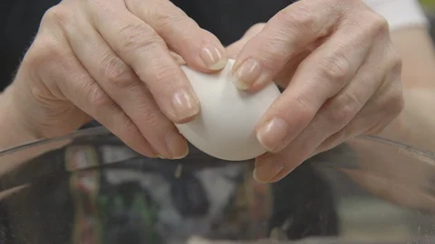 Baker cracking eggs into a bowl for dessert recipe Stock Footage 104866508