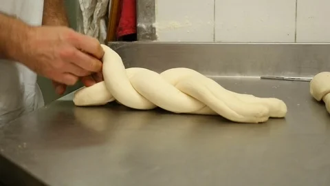 The baker creates a braid of bread Stock Footage 76181669