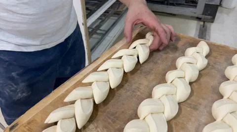 Baker creating a loaf after cutting the dough. Baker making a bread loaf. Stock Photos