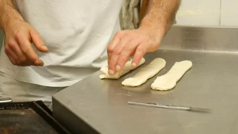 Baker cuts and rolls the bread pasta Stock Footage 76125947