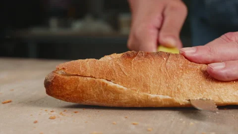 A baker cuts a baguette with a knife Stock Footage 201548165