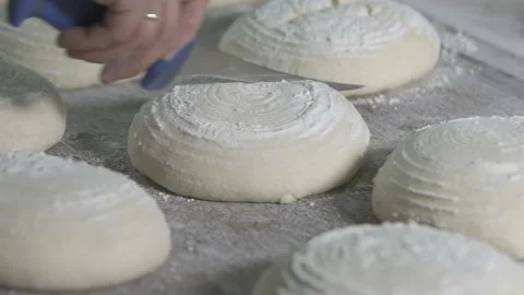 Baker cuts bread dough. slow motion Video stock 100736498