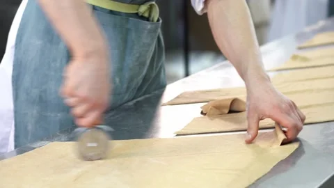 The baker cuts the dough into dumplings. Layers of dough are stacked in a stack. Stock Footage 151629141