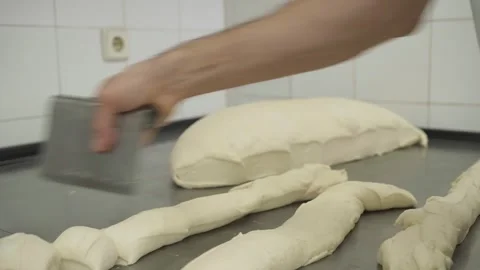 Baker cuts dough loafs into small pieces in a bakery 스톡 동영상 251364331