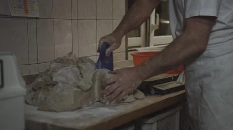 A baker cuts dough into pieces and weighs this then Stock Footage 66438734
