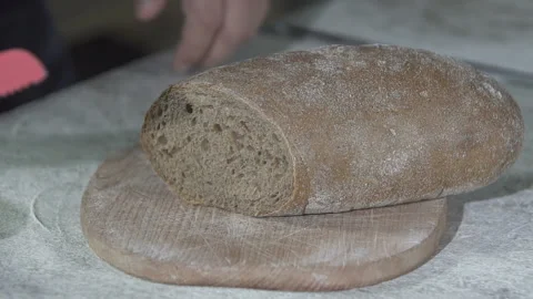Baker cuts hot fresh bread. slow motion Vídeo Stock 100736834