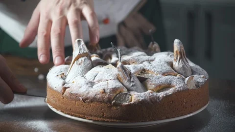 Baker cuts a piece of pear cake. Pie and bakery. Bake food on cuisine. Stock Footage 124755883