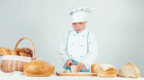 Baker cutting and eating slice of bread isolated on white background Stock Footage 66529702