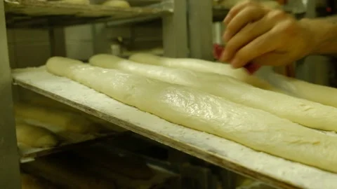 Baker cutting baguettes with a knife to make the baking pattern Stock Footage 141275373