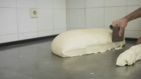 Baker cutting bread dough into loafs in a bakery 스톡 동영상 251363764