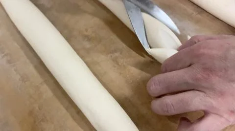 Baker cutting the bread dough with a pair of scissors. Stock-Fotos