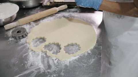 Baker Cutting Cookie Dough on a Flour-Dusted Stainless Steel Table Stock Footage 321363341