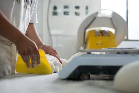 Baker Cutting Fresh Bread Dough Stock-Fotos