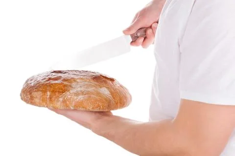 Baker cutting fresh made bread. Stock Photos