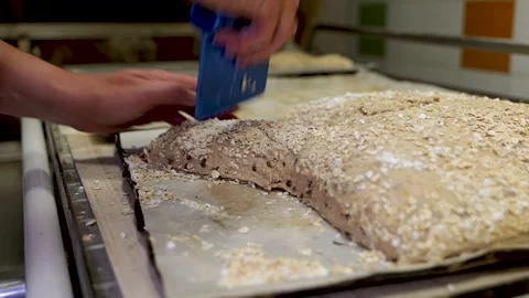 Baker Cutting Oat-Coated Dough With Scraper Stock Footage 340933557