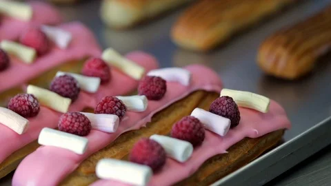 Baker decorates eclairs slider shot Stockbeeldmateriaal 96421795