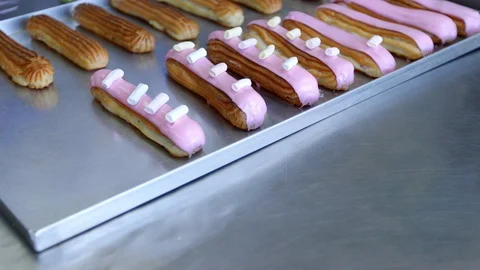 Baker decorates eclairs slider shot Vídeos de archivo 96423342