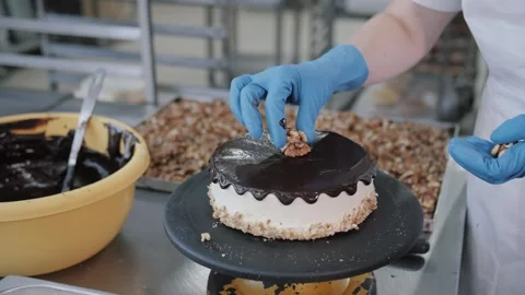 Baker Decorating Chocolate Walnut Cheesecake. Confectionery Production. Video stock 321811734
