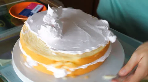 Baker decorating top layer with whipped cream Stock Footage 25007022