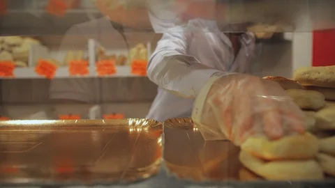Baker Displaying Products On Bakery Window For Customer Choice Видео 107667421