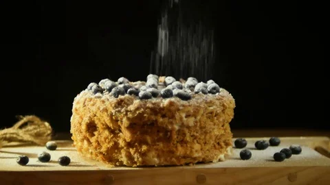 A baker dusting with sugar glaze powder over a delicious decadent puff dessert Video stock 80793365