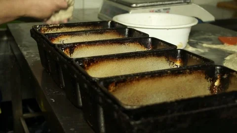 Baker fills forms dough before baking Stock Footage 71815562