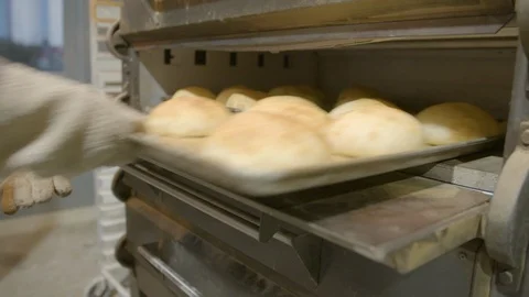 Baker flipping bun trays back in the industrial oven Stock Footage 87612196
