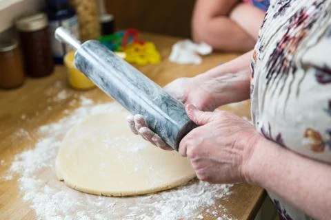 Baker flouring a rolling pin to prep for sugar cookie dough Stock Photos