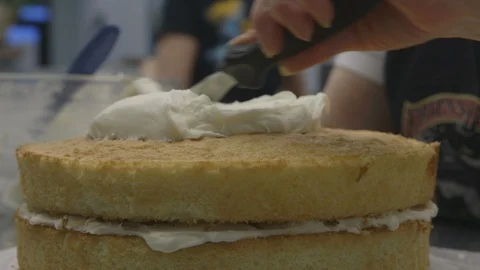 Baker frosting a two layer cake Stock Footage 104866578