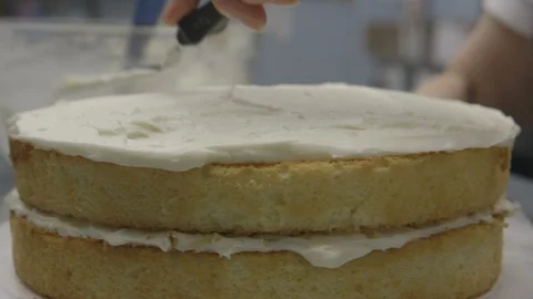 Baker frosting a two layer cake Stock Footage 104866760
