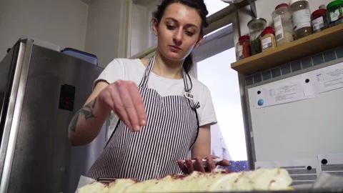 Baker girl preparing apple pie or dessert in kitchen, pouring fruit before Stock Footage 168276535