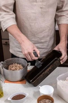 Baker greases a bread baking dish Stock Photos