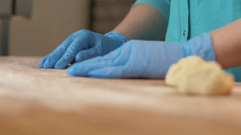 Baker hand making balls from dough for patties on wooden table in bakery shop Stock Photos