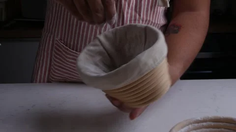 Baker hand spring flour to proofing banneton basket. Stock Footage 306158338