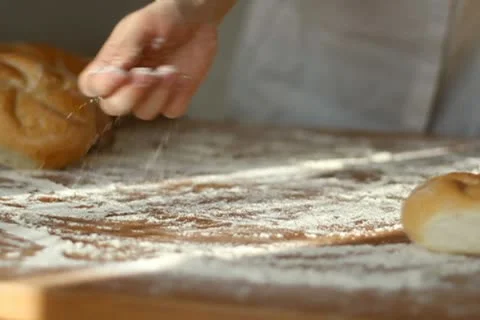Baker hand throwing flour on the table and kneading dough, slow motion Stock Footage 10735187