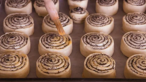 Baker hands with a brush covers the pastry with egg mixture. Closeup. Video stock 101140703