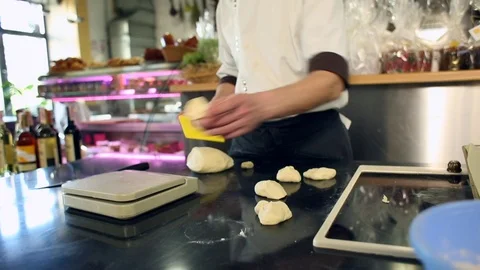 Baker hands cutting dough in flour on table Vídeos de archivo 75074239