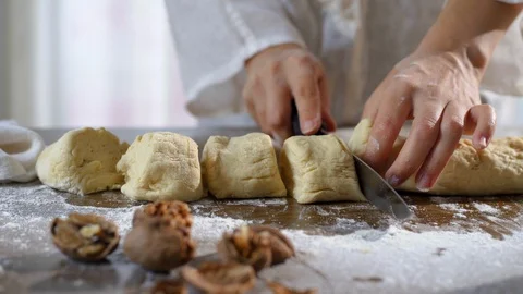 Baker hands cutting dough in flour on table. Stock Footage 96404224