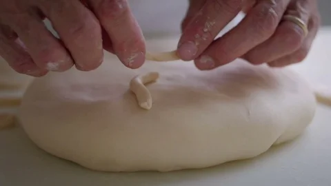 Baker hands decorating bread with ecclesiatical symbol Video stock 76559688