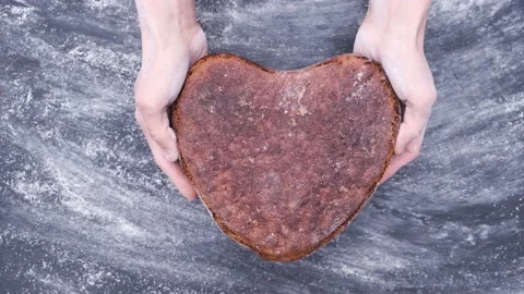 Baker hands holds rye whole grain sourdough artisan bread in shape heart Видео 130495255