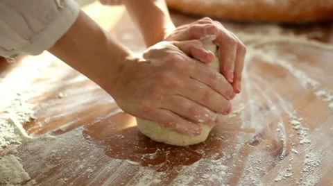 Baker hands kneading dough in flour on table, slow motion HD Stock Footage 10725648